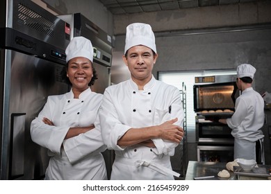 Pastry foods professional partners, two happy chefs team staff in white cooking uniforms stand, arms crossed with confidence, cheerful smiles with commercial culinary jobs in restaurant kitchen. - Powered by Shutterstock