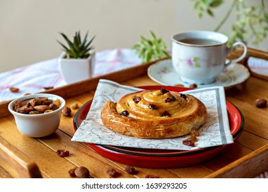 Pastry rolls with honey and dry grapes served with tea, almond and dry grapes aside