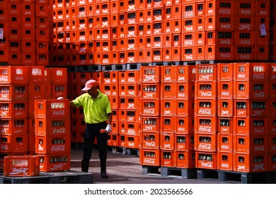 PASURUAN, INDONESIA – JANUARY 10, 2013 : A worker control a stack of crates of empty Coca-Cola bottles. 