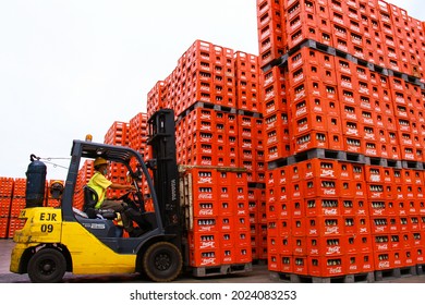 PASURUAN, INDONESIA – JANUARY 10, 2013 : Forklift truck carries a stack of crates of empty Coca-Cola bottles in factory. 
