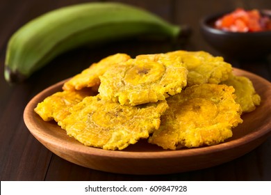 Patacon or toston, fried and flattened pieces of green plantain, traditional snack or accompaniment in the Caribbean, photographed with natural light (Selective Focus on the front of the top patacon) 