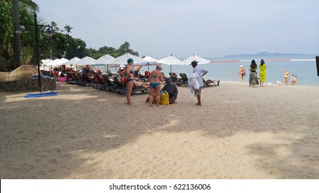 Pataya, Thailand - March 25, 2017 The Thai seller (sit ans white shirt) try to sell their cloth to The Europe Tourist  (in Bikini) who stay in vacation at Pataya beach