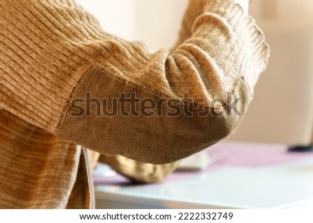 Patch on a man wool sweater. Striving to reduce the amount of waste and reasonable consumption, fashionable needlework. Selective focus