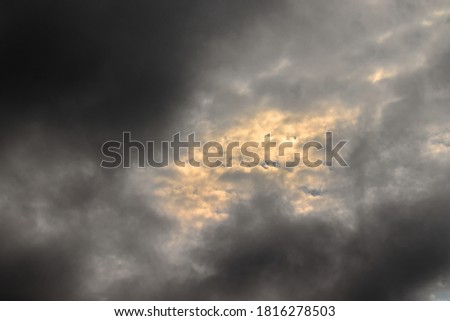 patch of sky with clouds illuminated by twilight light, surrounded by thin gray clouds - POA, SAO PAULO, BRAZIL.