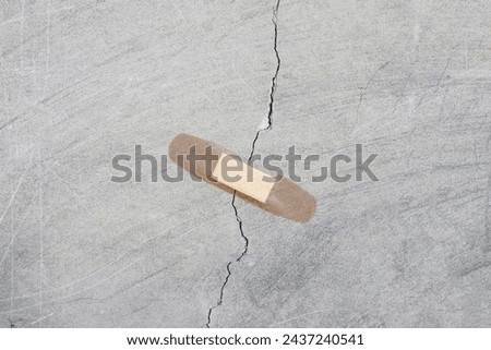 a patch is stuck on a crack in a concrete wall. Unscrupulous repair concept. 