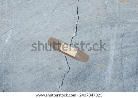 a patch is stuck on a crack in a concrete wall. Unscrupulous repair concept. 