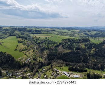 Patchwork fields bordered by dense forest, visible habitat edges and wildlife corridors, seasonal contrast