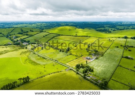 Patchwork fields spread across County Meath, Ireland, under heavy cloud. Peaceful Boyne Valley farming landscape of hedgerows, pasture and rural roads.
