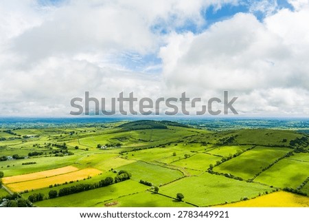Patchwork fields spread across County Meath, Ireland, under heavy cloud. Peaceful Boyne Valley farming landscape of hedgerows, pasture and rural roads.