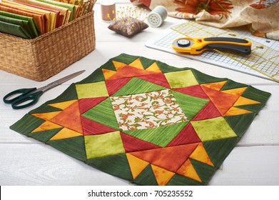 Patchwork orange-green block, quilting fabrics, sewing accessories