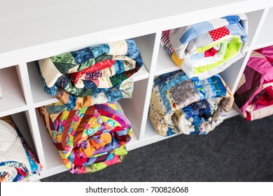 Patchwork, Sewing And Fashion Concept - Colorful Finished Quilts In The Studio At White Shelves With Few Storage Compartments, The Warehouse Of Finished Products, Top View