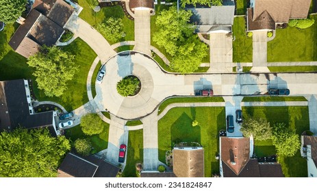 Patchy road in cul-de-sac with lower end houses downward rooftop aerial view
