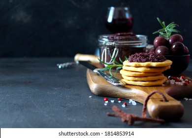 Pate of olives in a jar with crackers and olives served with red wine on dark background. Top view with copy space. - Powered by Shutterstock