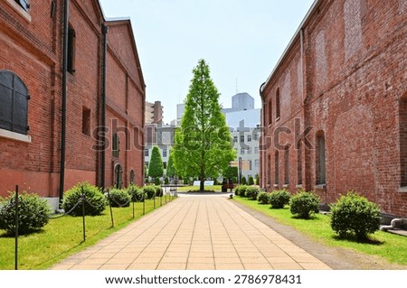 Path between historic red brick warehouse buildings at Noritake no Mori in Nagoya, Japan. 1