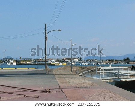 A path in the fishing port that leads to the breakwater that forms
the entrance to the port.
This is a scene of a Japanese port located on the shores of the Seto Inland Sea National park of Japan.
