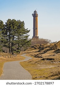 A path leads through the dune landscape to the lighthouse on the island of Norderney, Germany