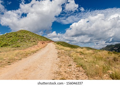 Path in mountains under dramatic sky