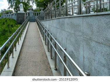 A path with a railing for the disabled in the park.