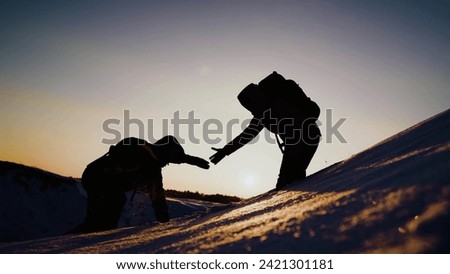 Path to success through difficulties Concept. Travelers climb one after another on rock. Teamwork of business people. Climbers silhouettes stretch their hands to each other, climbing to top of hill.