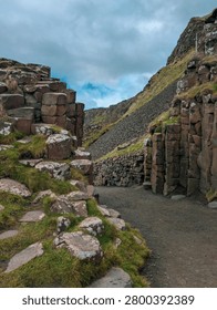 Path Through Giants Causeway Basalt Columns with Grassy Hill