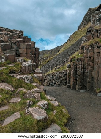 Path Through Giants Causeway Basalt Columns with Grassy Hill