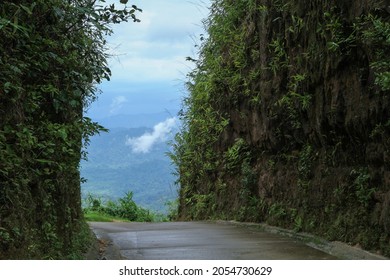 The Path Through The Gorge In A Cloudy Atmosphere. Road That Cuts Through Mountain. (The Pictures Has Noise And Soft Focus)