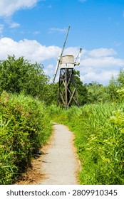 Path towards Boardman's drainage mill near Ludham in North Norfolk, UK.  A timber open framed mill, one of only left on the Broads, in portrait orientation