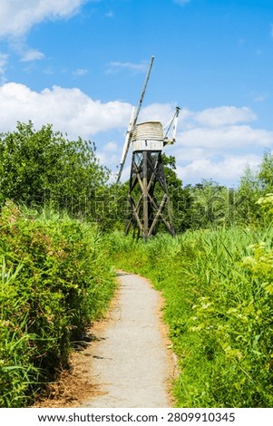 Path towards Boardman's drainage mill near Ludham in North Norfolk, UK.  A timber open framed mill, one of only left on the Broads, in portrait orientation