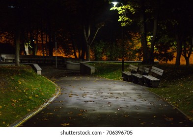 Path And Wooden Benches In A City Park At Night.