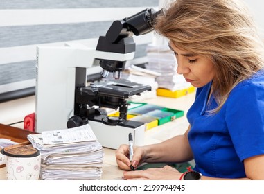 Pathologist Working With Stained Tissue Biopsy On Glass Slides In The Laboratory