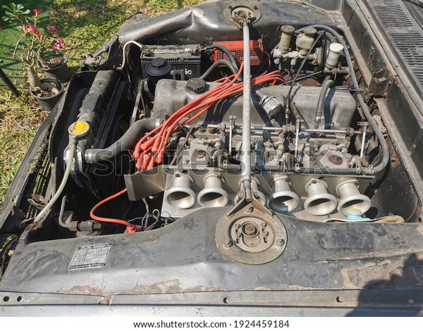 NAKHON​ PATHOM, THAILAND, FEBRUARY​25,2021​:The\
broken engine room of the old vintage car has been parked for a\
very long time. And some parts will not be able to find replacement\
or repair parts\
\
