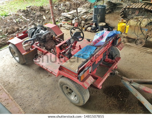Pathum Thani,\
Thailand - August 2019: Thai agricultural vehicles (E Tan) diesel\
engines start with the key with towing trailers at the end of the\
car.  Park in the garage.\
Prepared.