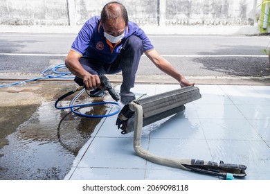 Pathum Thani-THAILAND - Nov. 4, 2021 : Technician Man In Medical Mask Worker Cleaning The Air Conditioner Cooling Coil