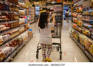 Pathumwan, Bangkok / Thailand - 09/09/2020: The Back View Of A Young Asian Girl Pushing A Shopping Cart Along An Aisle At A A High Class Supermarket On The Top Floor Of Central Word Shopping Center. 