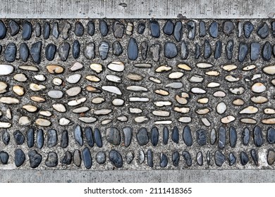 Pathway Decorated With Smooth Embossed Pebble River Stone (sea Stone) Embedded In Concrete Floor, Garden Walkway For Foot Reflexology Massage, Close-up Top View