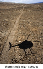 Pathway Leading Through Rocky Terrain With Shadow Of Helicopter Flying Overhead In Maui, Hawaii.