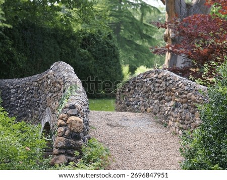 Pathway over a cobble stone bridge in a park.