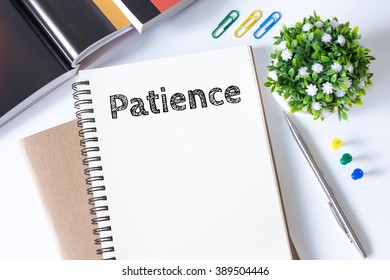 patience word message on white paper book and copy space on white desk / business concept / top view - Shutterstock ID 389504446