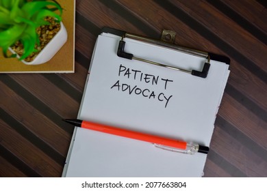 Patient Advocacy write on a paperwork isolated on Wooden Table.