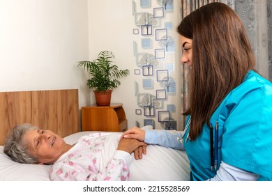 Patient in bed nurse helping - Shutterstock ID 2215528569