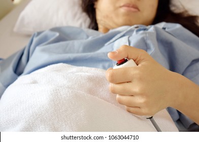 The patient in the bed is pressing the emergency button to call the doctor. Concept for medical treatment. Selective focus.