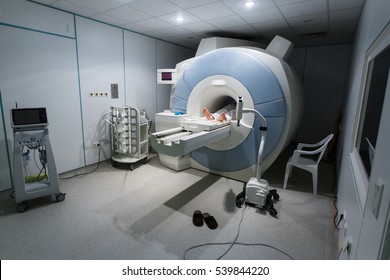 Patient being scanned and diagnosed on a MRI (magnetic resonance imaging) scanner in a hospital. Modern medical equipment, medicine and health care concept.  