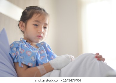 Patient Child Sitting On Hospital Bed With Saline Solution Intravenous