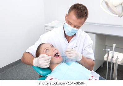 Patient At Dentist Office. Top View Of Teenage Girl Sitting At The Chair At The Dental Office While Doctor Examining Teeth