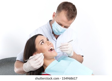 Patient At Dentist Office. Top View Of Young Woman Sitting At The Chair In Dental Office And Doctor Examining Teeth