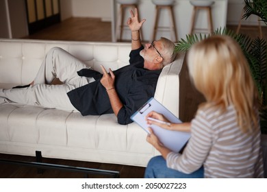 Patient And Doctor. A Mature Man Is Lying On The Couch During A Session With A Psychologist. Straight Talk, Problem Analysis.