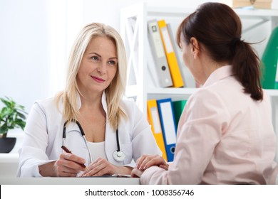 Patient In The Doctor's Office, She Is Receiving Prescription Medicine. Realistic Images Without Retouching With Their Own Imperfections. Selective Focus.