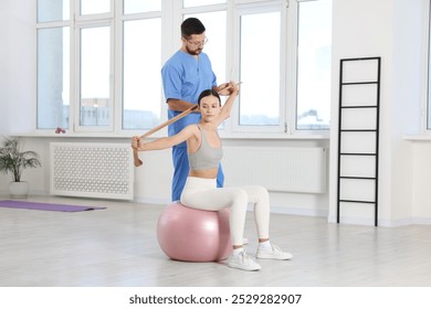 Patient exercising under physiotherapist supervision in rehabilitation center - Powered by Shutterstock