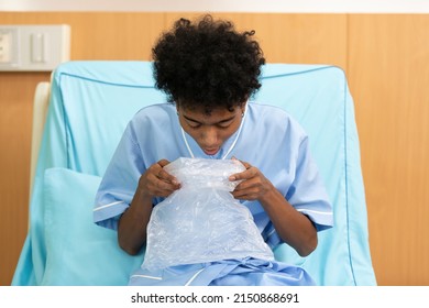 Patient Feeling Stressed And Vomiting Into Plastic Bag On Bed In Hospital