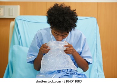 Patient Feeling Stressed And Vomiting Into Plastic Bag On Bed In Hospital